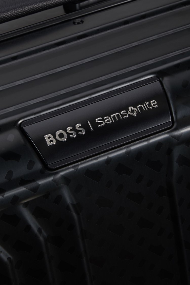 BOSS與Samsonite標誌還出現在皮革提把與正面金屬飾牌上，成為細節亮點。圖／Samsonite提供