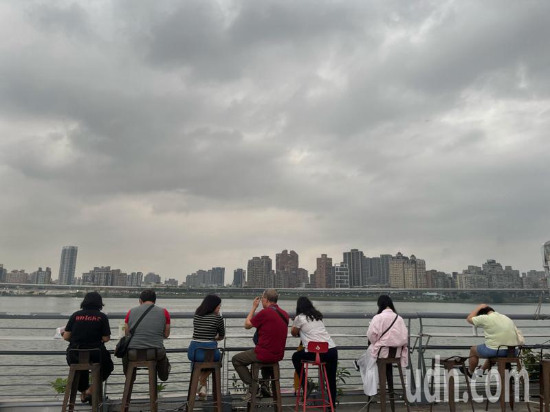 受鋒面接近影響，台北市傍晚時天空出現烏雲，但也帶來些許涼爽微風，許多民眾享受徐徐涼風。記者潘俊宏／攝影
