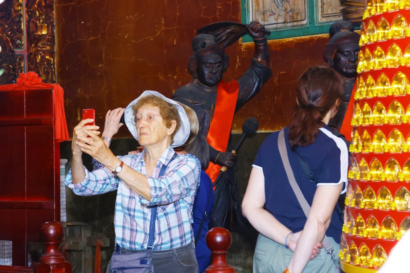 法国游客对于台湾庙宇文化十分好奇，沿途不断拍录。图／嘉义市政府提供