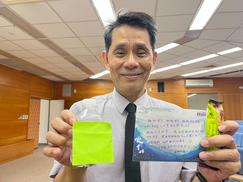 东华大学校长徐辉明拿出学生鼓励的卡片，为他加油打气。记者王思慧／摄影