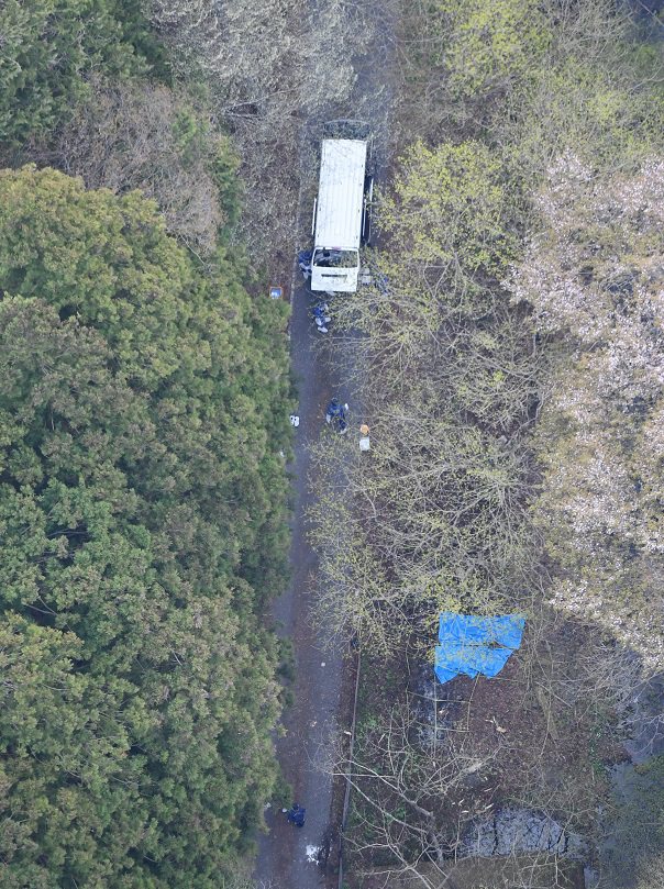 日本栃木縣那須町深山河畔16日發現了兩具燒焦的遺體，17日的空拍照可見警察正在進行調查。路透