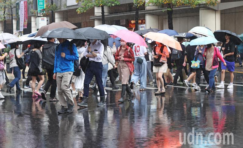 新北今天清晨下起倾盆大雨，雨势持续到上班、上学交通尖峰时段，不少步行的通勤族与学生，即使撑伞也难以完全抵挡雨势。记者杜建重／摄影