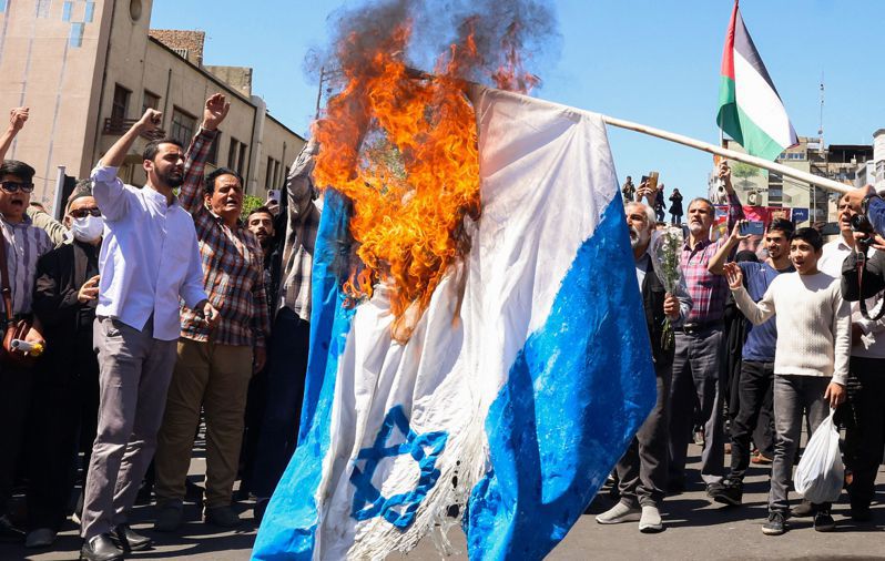 以色列表示將回應伊朗的飛彈和無人機攻擊。圖為伊朗民眾上街焚燒以色列國旗。法新社