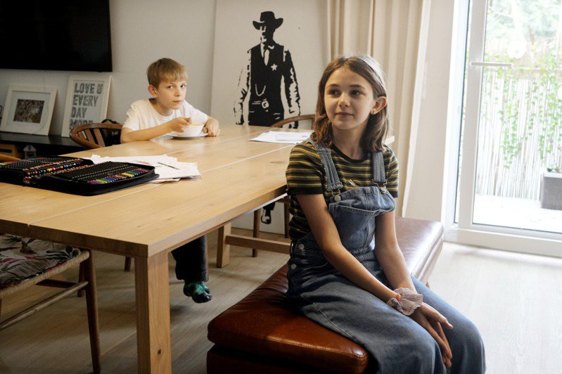 奥拉‧科札克和弟弟会在客厅长桌上写功课。她希望新规定施行后，有更多时间培养兴趣。（图／美联社）