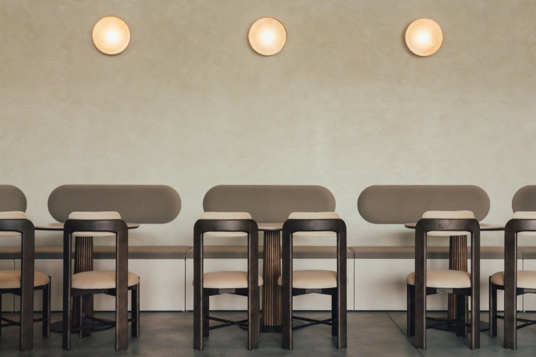 內部餐桌椅與擺設循著圓潤線條堆疊出俐落氛圍。 圖／留白計畫提供
