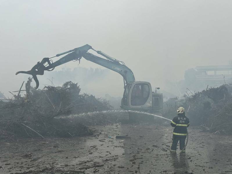 彰化县田中镇一处杂木场今失火，消防人员出动挖土机隔开杂木。图／民众提供
