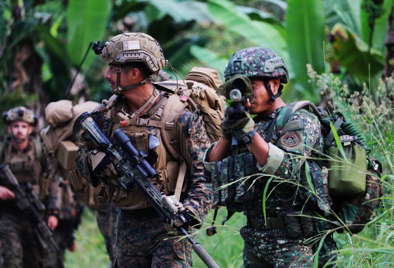 美軍（左）和菲律賓軍人（右）十二日在菲國南部山區演習。（歐新社）