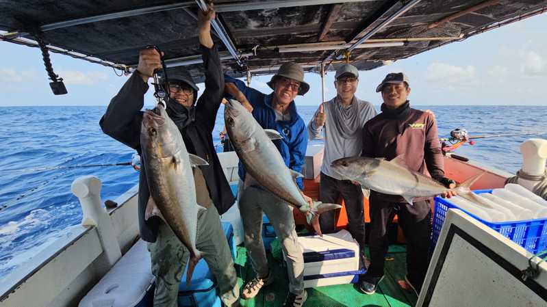 「協星號」娛樂漁船的釣客，開心展示用南魷釣起的大尾紅魽。記者王勇超／翻攝