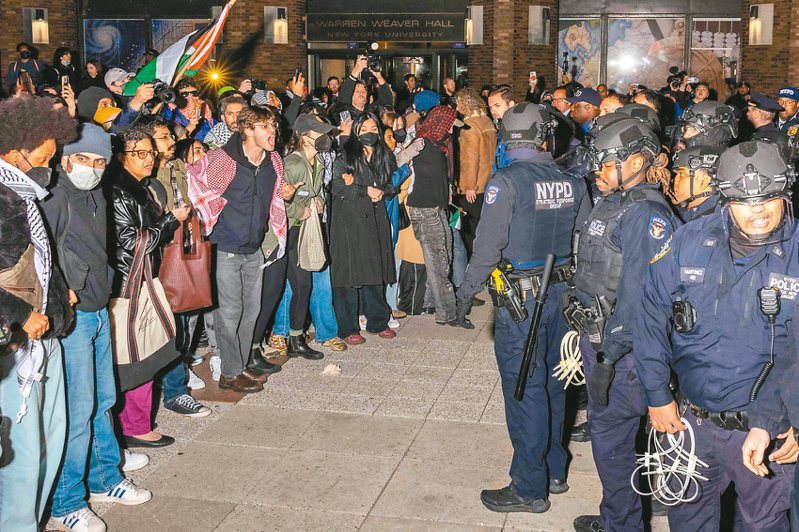 美國紐約市警方廿二日在紐約大學校園逮捕支持巴勒斯坦的學生後，與其他示威者對峙。（法新社）