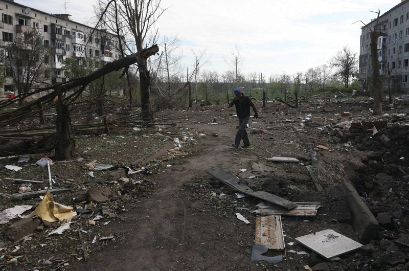 在烏克蘭頓內次克州阿夫迪夫卡附近的奧切列季涅村，一位村民15日走過遭砲火摧毀的公寓大樓。俄軍據報於21日攻入了奧切列季涅村。法新社
