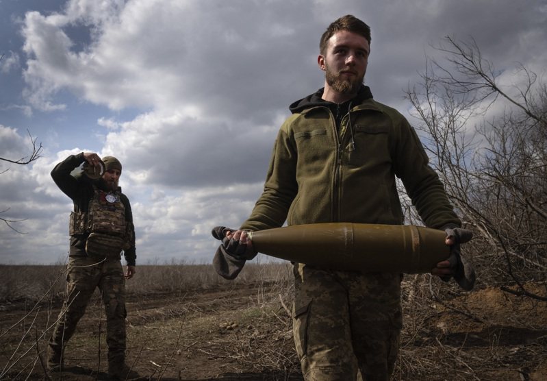 烏東城鎮巴赫姆特附近的烏克蘭軍人上月徒手搬運砲彈。美聯社