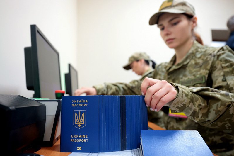 烏克蘭邊防人員在西部利維夫地區的鐵路出境檢查站整理烏克蘭護照。路透