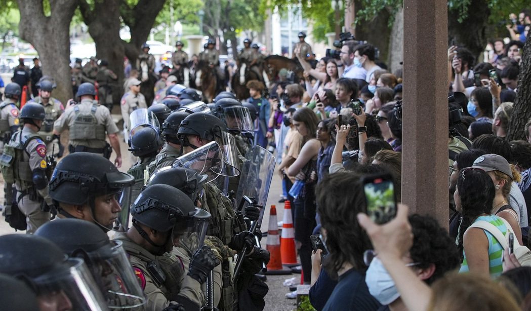 圖為德州大學奧斯汀分校的抗爭，警察與學生對峙。類似的聲援示威在美國各大學蔓延，參...