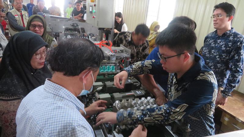 台灣技術團團員向印尼政府人員、農業學校代表及農民示範操作台製自動包裝機。圖／台灣駐印尼技術團提供（中央社）