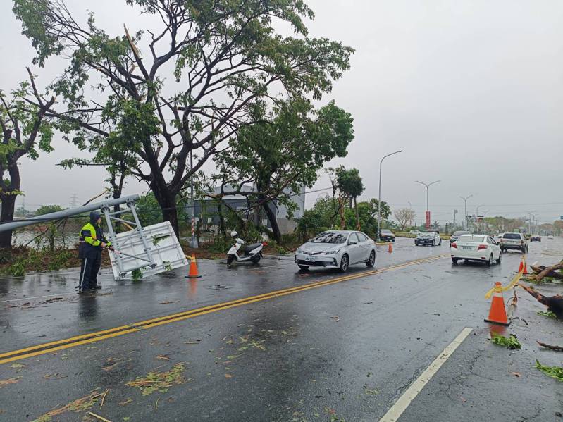 高雄湖內區東方路往茄萣區方向，今天清晨下起大雷雨，造成路樹與路牌倒塌，警方派人到場指揮交通。記者王勇超／翻攝