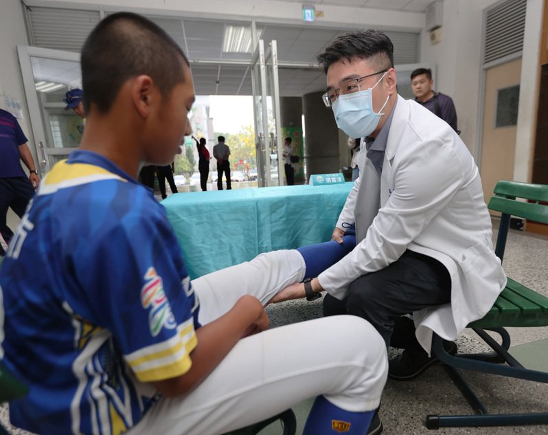 骨科医师张富淳（右）为五福国中棒球队运动员检查运动伤害。记者刘学圣／摄影