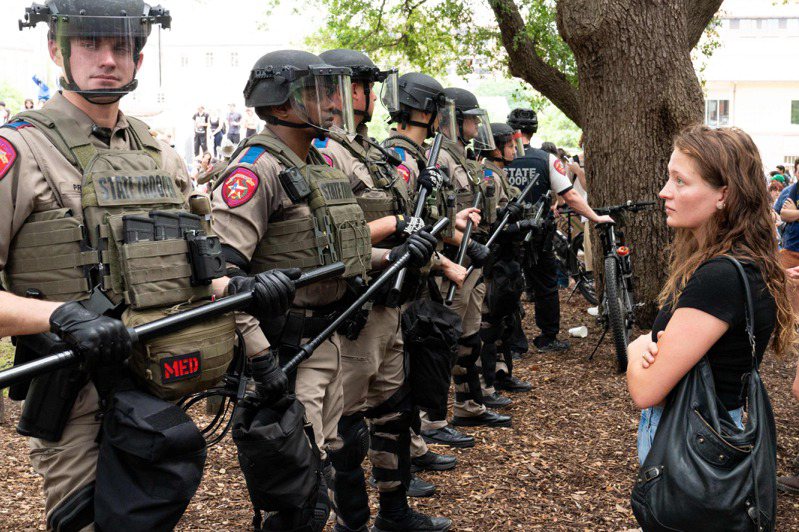 美国奥斯丁德州大学学生廿四日在校园示威支持巴勒斯坦，一名女生默默看着奉命前往清场的德州州警。（法新社）(photo:UDN)