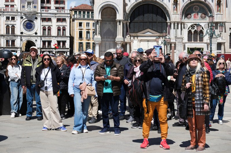 義大利威尼斯25日起開始向一日遊旅客收取5歐元（約新台幣175元）入城費。圖為旅客在威尼斯聖馬可廣場上拍照。路透