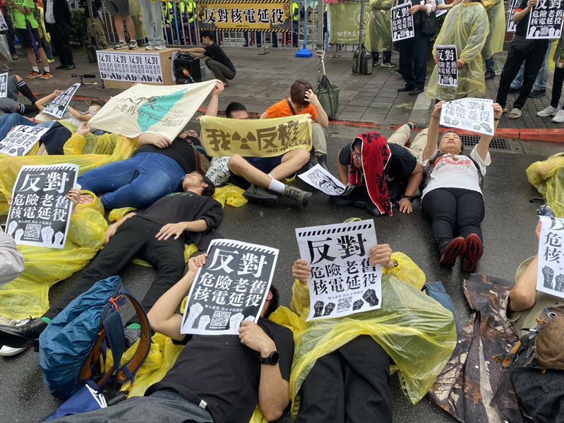 反核團體今舉辦「427反核占領行動10周年」活動，近百人今下午冒雨在立法院前就地躺下，模擬核災演習。記者葉冠妤/攝影