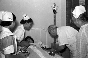1955年5月4日，貧病女作家萬綺萍到台灣療養醫院就診，美籍主任醫師卜凱士（右二）診斷，她久病貧血，需要及時大量輸血才能保命。圖／聯合報系資料照片