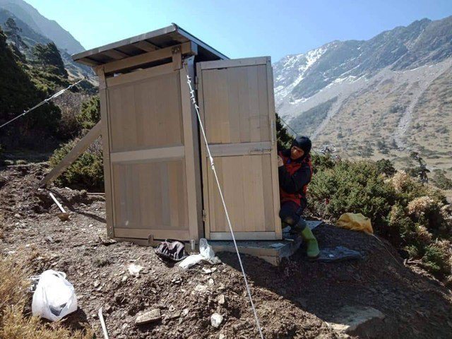 三名高山協作員背著數十公斤的建材，攀上南湖大山修建圈谷山屋廁所。圖／全蔣清提供