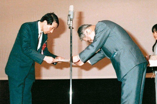 余幸司(左)1982年赴日本大阪演講，恩師久木田淳致贈感謝狀。 圖／余幸司提供