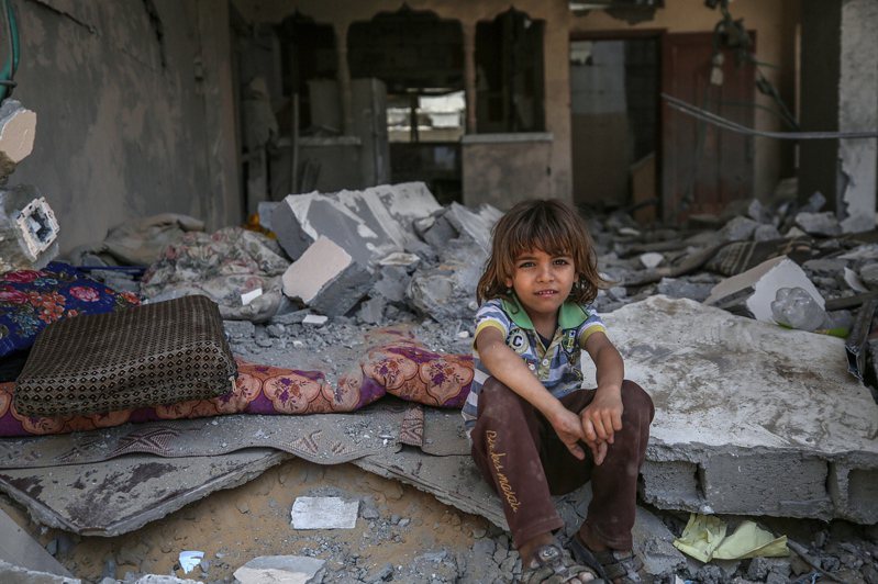 停火後，一名巴勒斯坦小孩坐在回到已成廢墟的家中。（歐新社）