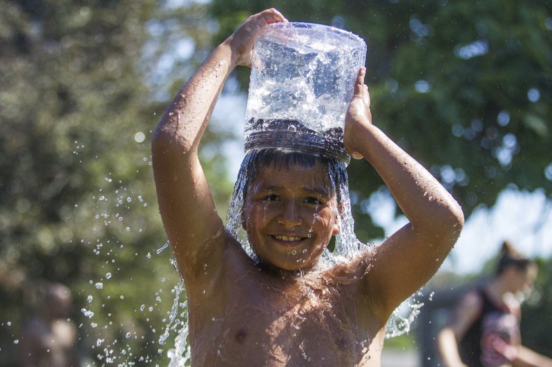上月為北美歷來最熱6月，歐洲也歷經第二熱的6月。圖為華盛頓州一名兒童盛水澆到全身，以便降溫。(美聯社)