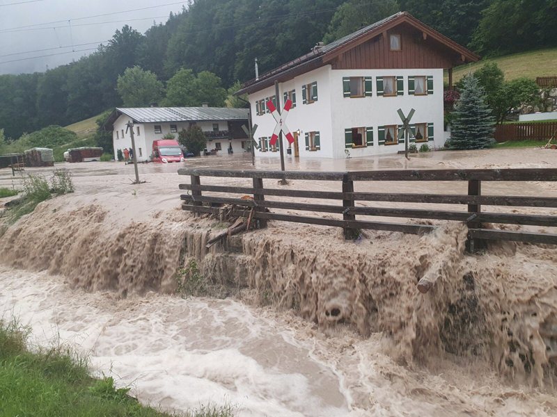 德國Bischofswiesen地區的民房在洪水中，危危可岌。(美聯社)