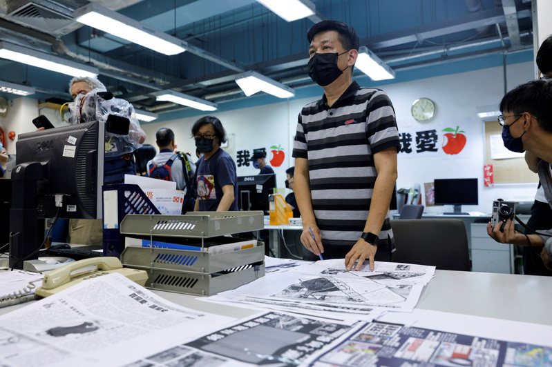 香港蘋果日報執行總編林文宗(中)在出刊最後一份報紙的前一晚在公司裡校對報紙和排版。(路透)