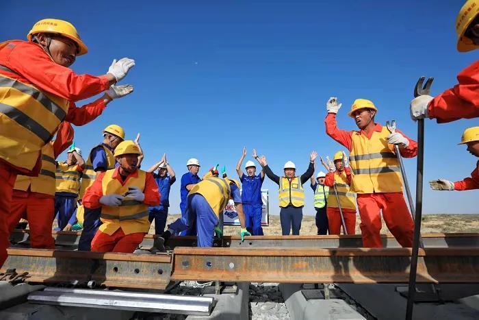 環塔克拉瑪幹沙漠鐵路線正式閉環，現場工人鼓掌慶祝。(取材自中國鐵路)