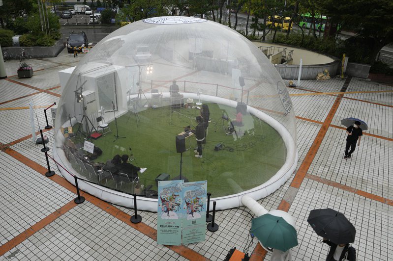 首爾音樂人8日在一個塑膠充氣帳幕裡做現場表演。（美聯社）