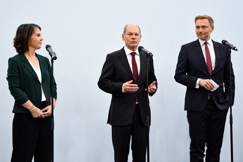 德國財政部長蕭茲（中）所屬的社會民主黨與綠黨、自由民主黨宣布達成組成新政府的初步協議。左為綠黨共同主席貝爾伯克，右為自由民主黨黨魁林德納。（路透）