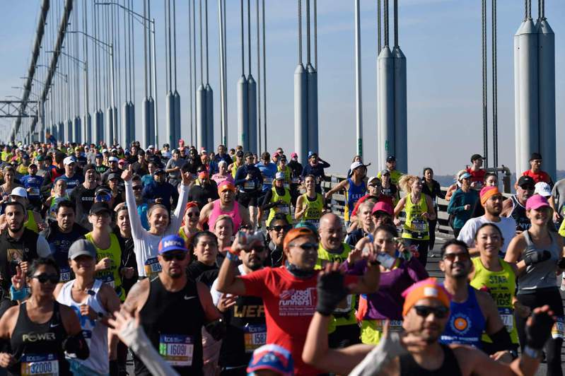 因为疫情而停办一年的纽约马拉松，7日在秋阳照耀下，亮丽登场，来自世界各地，五湖海的约3万300多名完全接种的长跑者，热烈参加盛事。图为上万跑者一脸兴奋，自史泰登岛区起跑，跨越维拉札诺大桥进入布鲁克林 区，展开赛事。(Getty Images)(photo:UDN)
