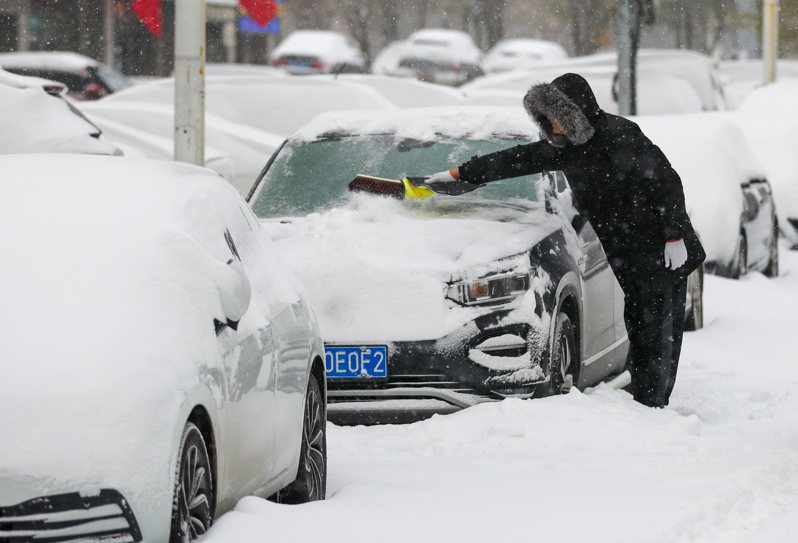 瀋陽市民清理汽車上的積雪。 （中新社）