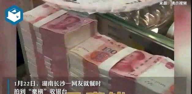 湖南長沙一飯店收銀台玻璃牆中放著大量百元大鈔。（視頻截圖）