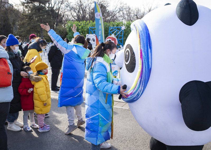 北京志願者正在整理冰墩墩大型玩偶，準備引導民眾合影。(中新社)