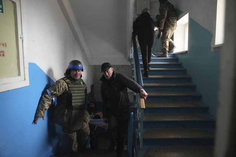 砲声隆隆已成为乌克兰的日常，人民无所畏惧，拒绝投降。图为俄军轰炸后，一名乌克兰军人和急救人员在抢救伤员。美联社(photo:UDN)