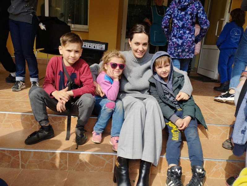 安潔莉娜裘莉（右二）30日現身烏克蘭西部城市利維夫，與當地兒童合影。（路透）