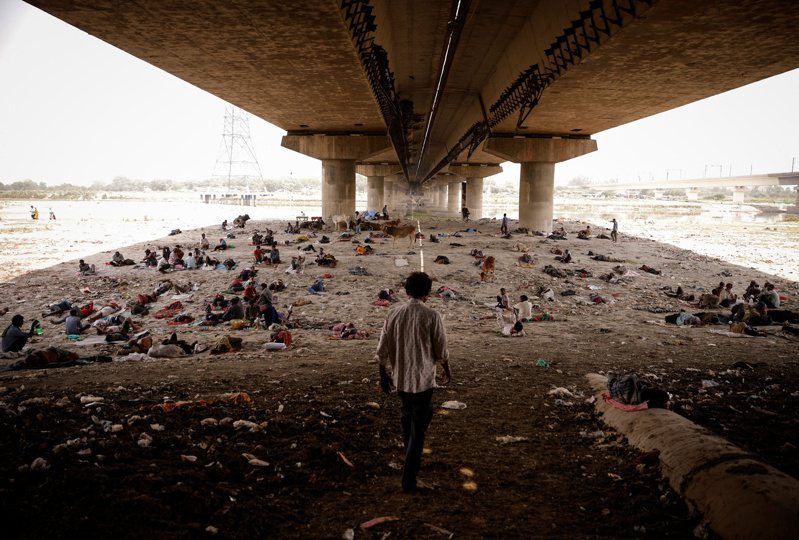 熱浪侵襲下，印度新德里2日有民眾躺在橋下的河床睡覺。路透