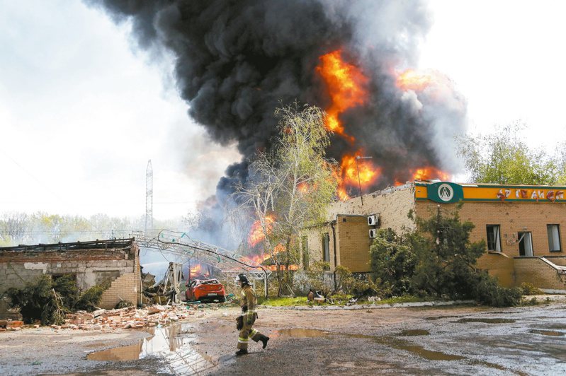 烏克蘭頓內次克郊區一處儲油設施4日遭攻擊起火，大量黑煙直竄天際，消防人員緊急出動滅火。(路透)
