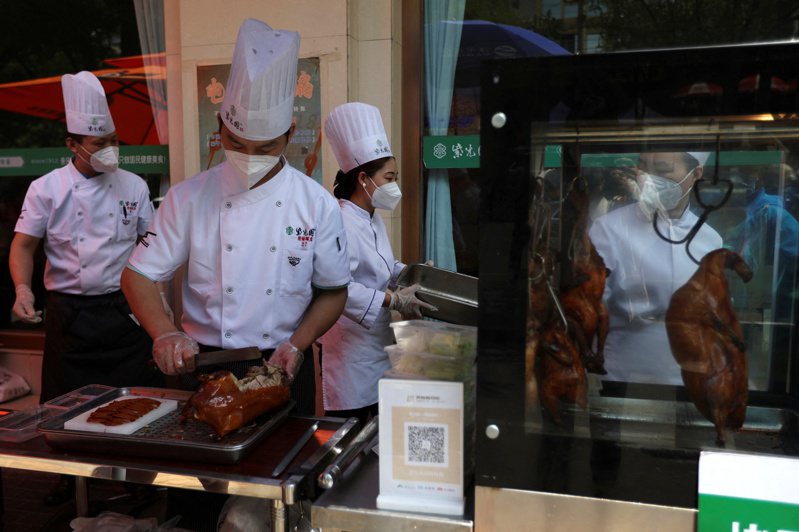 北京餐飲不准內用，師傅當街上演「北京烤鴨」片鴨秀。路透