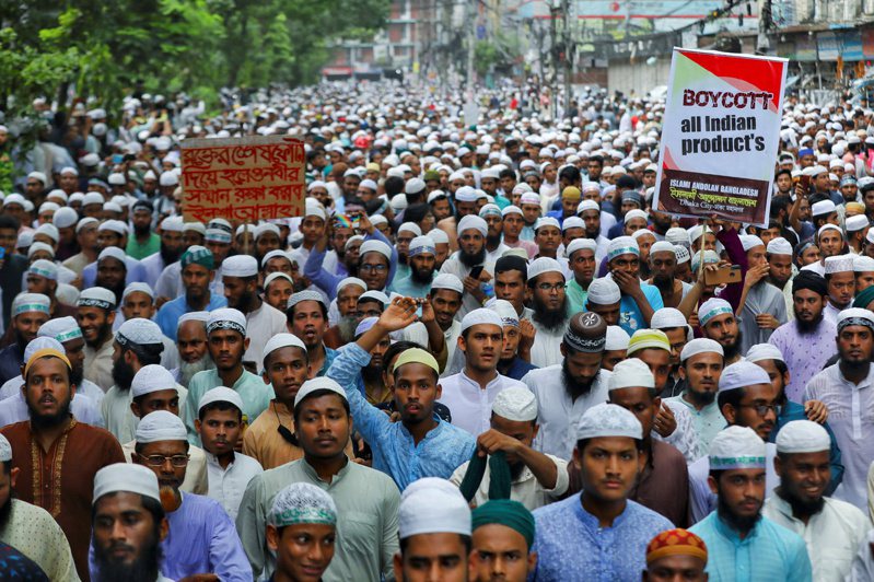 孟加拉達卡10日有大批穆斯林遊行，抗議印度執政黨高層早前侮辱先知穆罕默德的言論，有人舉起「杯葛印度貨」標語。（路透）