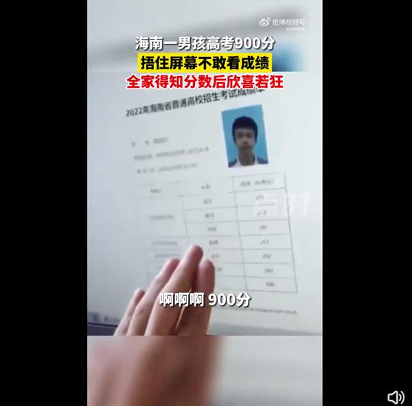 海南海口一男孩高考查分時，發現自己的高考成績為900分，摀住屏幕不敢看成績。（視頻截圖）