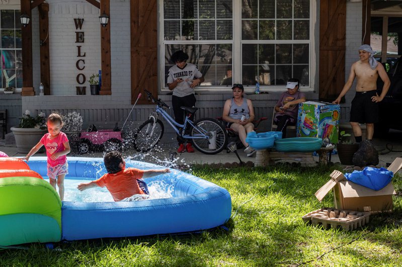 德州12日受热浪侵袭，气温达摄氏39度，达拉斯居民看着孩子戏水。（路透）(photo:UDN)