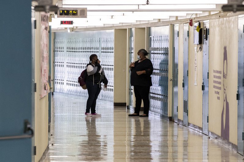 新学年的第一天，洛杉矶一处特殊学校的学生在空盪盪的走廊上和一名教师打招唿；美国200万人因受长新冠影响而无法工作。（欧新社）(photo:UDN)
