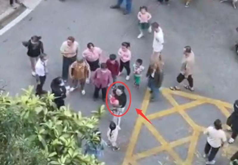 重慶一名3歲男童因其父母出門做核酸檢測墜樓，媽媽抱著小孩嚎啕大哭。圖／影片截圖