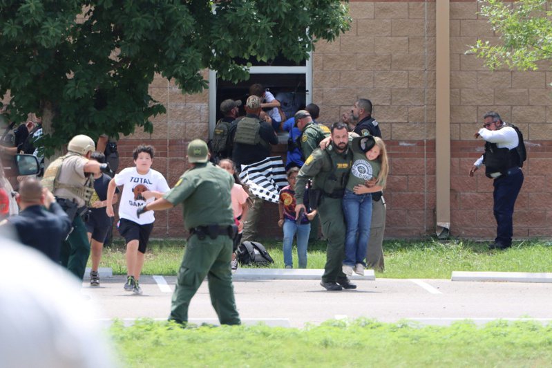 德州乌瓦德小学枪击案发生后，学生在警察指挥下跑离现场。(路透)(photo:UDN)