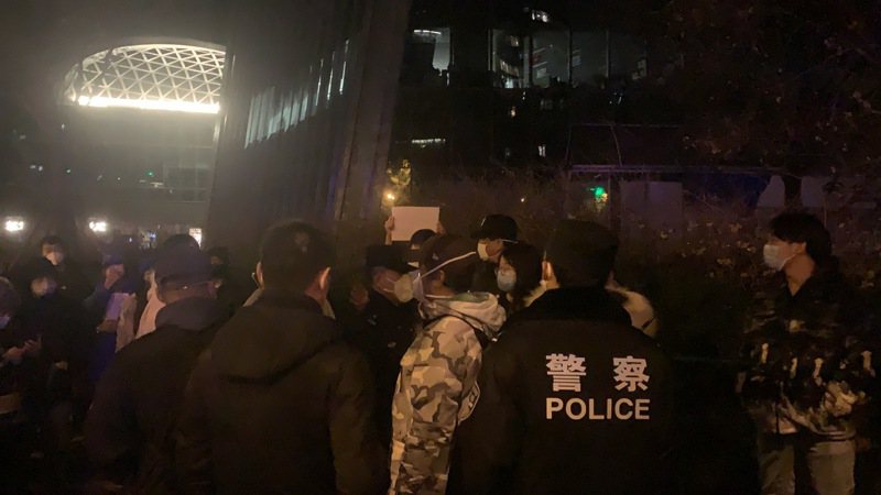北京市民27日深夜聚集在亮馬河，手持白紙抗議，遭警方驅離。（記者陳政錄／攝影）
