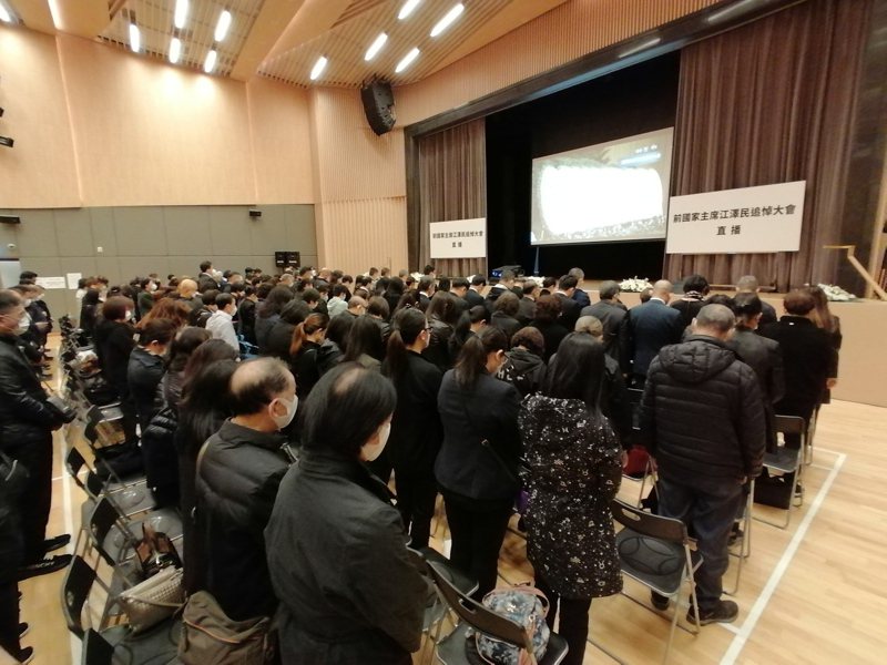 香港市民6日上午在北角社區會堂觀看江澤民追悼大會直播，並默哀悼念。（中通社）